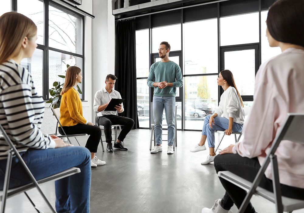 standing-in-group client at inpatient addiction program in a Group Therapy session - Inpatient Treatment & Outpatient Treatment